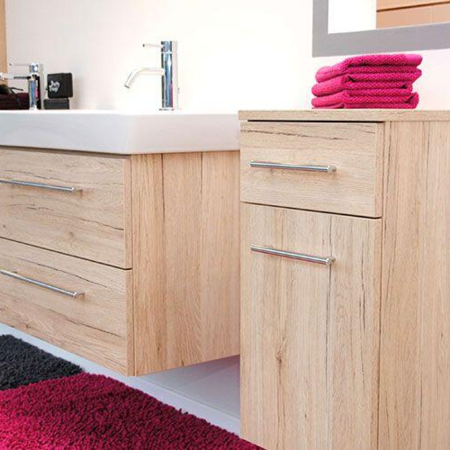 Badmöbel in Holzoptik mit rosa Handtüchern und rosa Badematte
