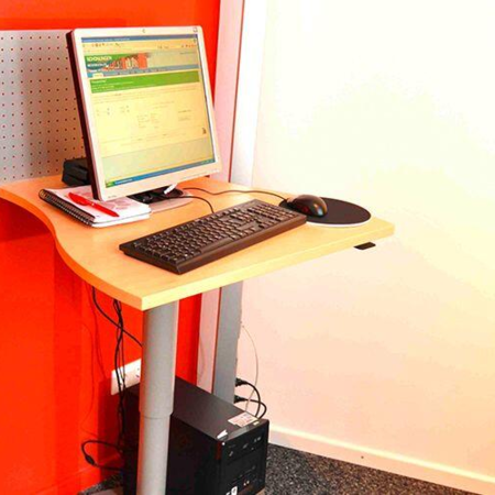Verstellbarer EDV-Arbeitsplatz an einer roten Wand