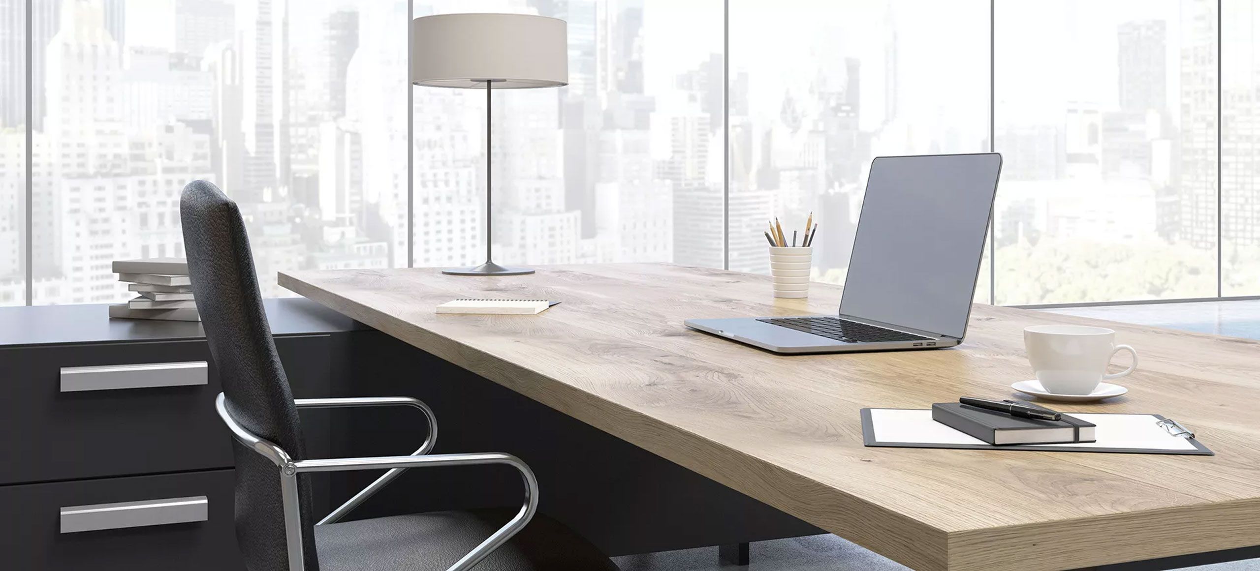 Moderner Bürotisch mit einem Laptop und anderen Utensilien darauf